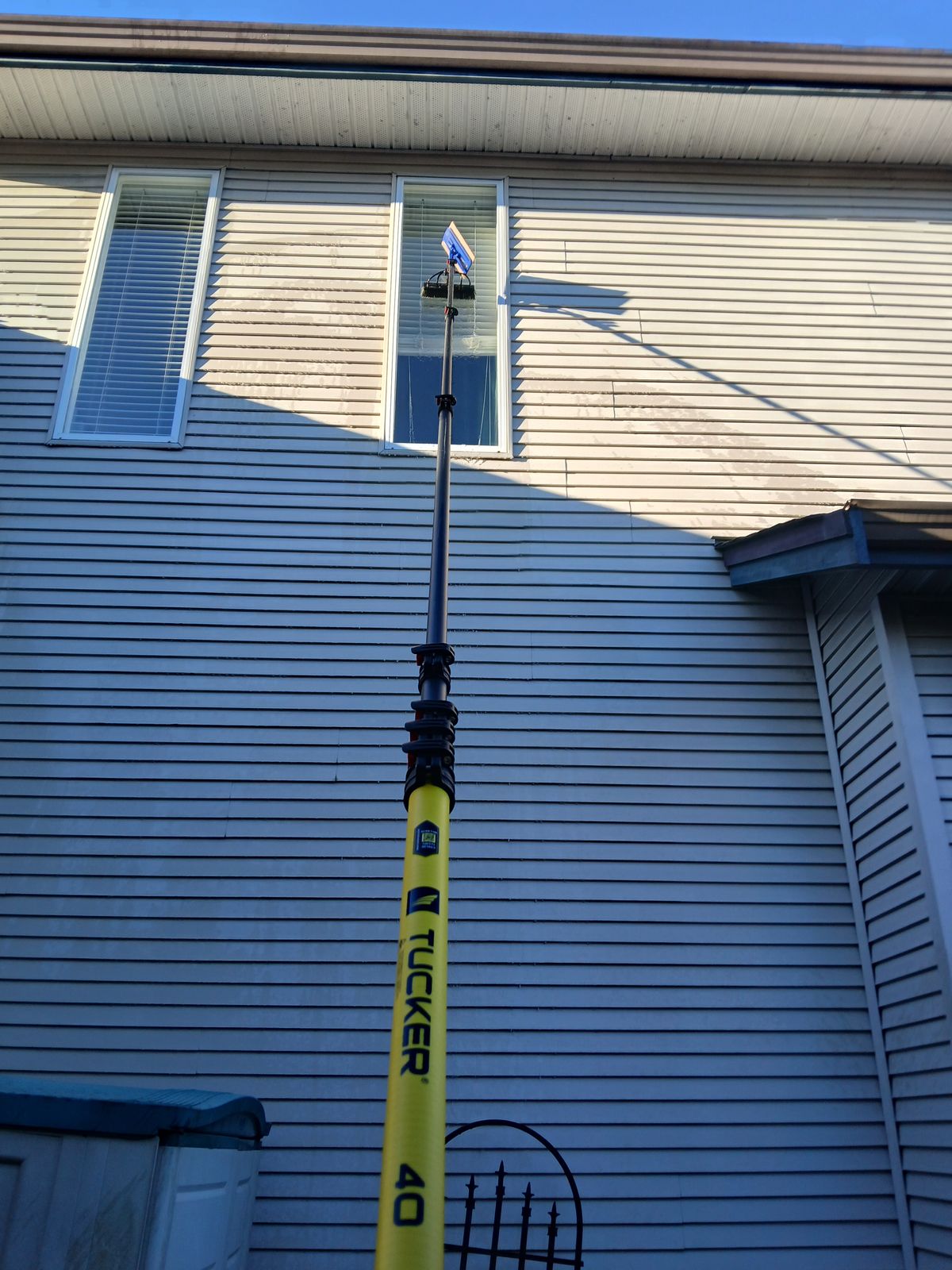 Water-fed pole cleaning residential windows in Surrey